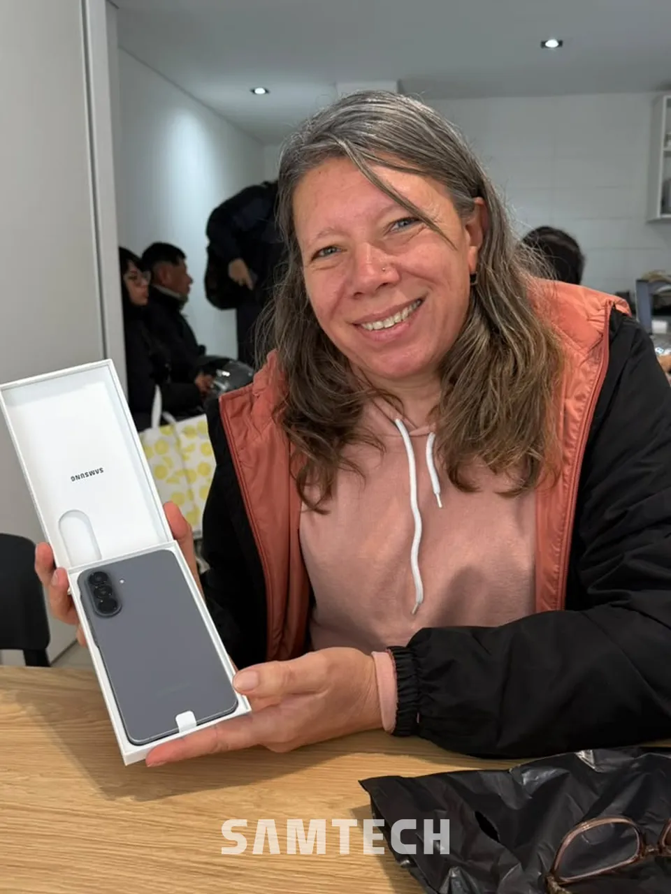 Cliente de SAMTECH con su celular nuevo en el local