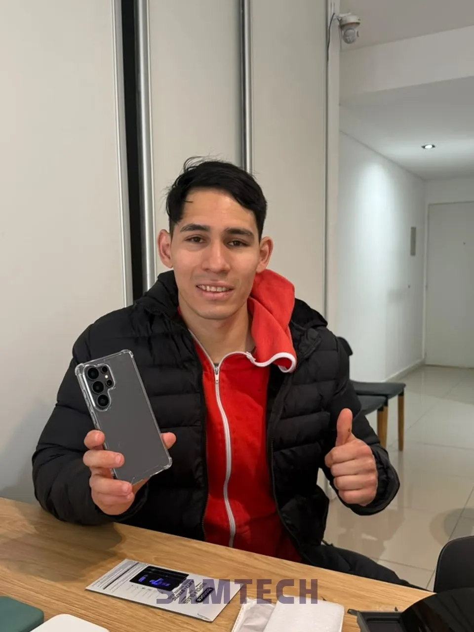 Cliente de SAMTECH con su celular nuevo en el local